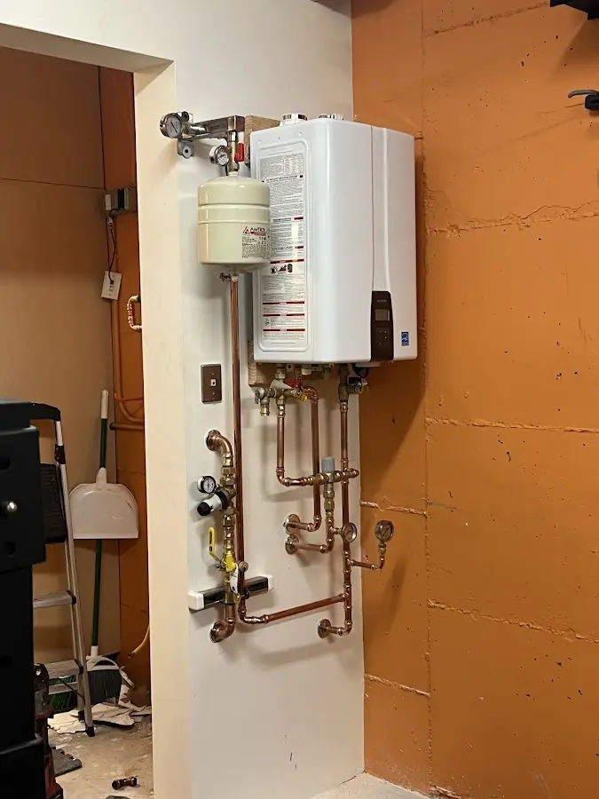 Plumbing technician inspecting water heater connections in Orofino
